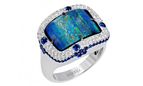 Magnificent fashion ring with a gorgeous blue-green sapphire with a diamond halo setting accented by more blue sapphires