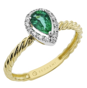 A yellow gold twist band, white gold and diamond halo around a pear shaped emerald by Zeghani