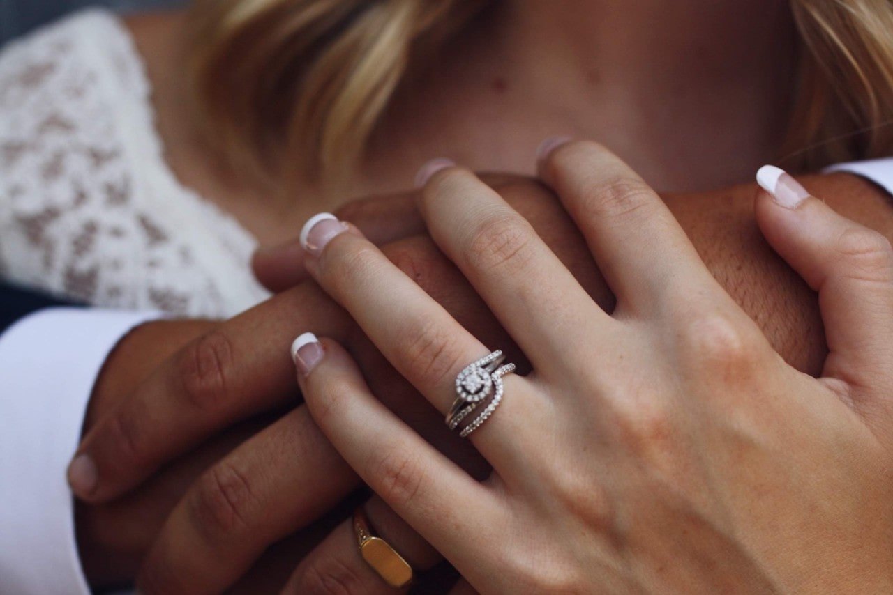 unique sidestone engagement ring holding hands