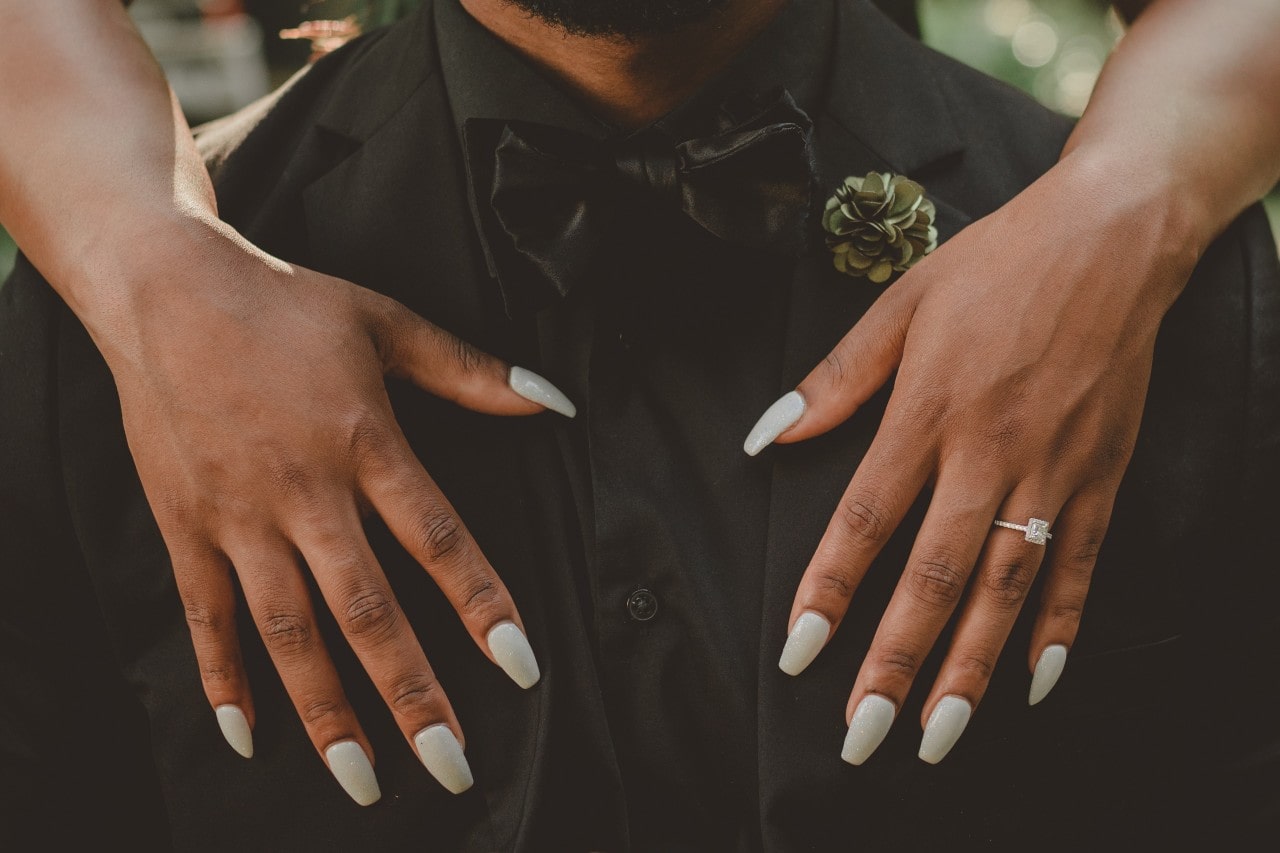 halo engagement ring on hands holding chest