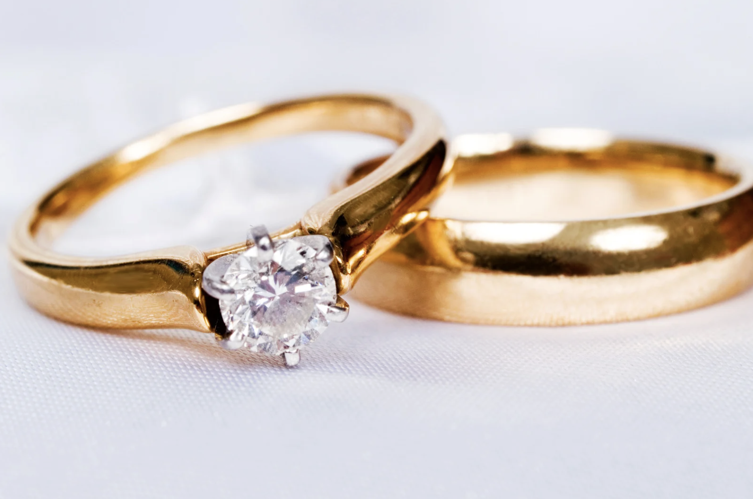 Two yellow gold wedding bands, one with a diamond and one polished. Two yellow gold wedding bands, one with a diamond and one polished.